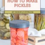 A jar of sliced pickled carrots sits in front of jars of pickled cucumbers and asparagus, with a text overlay reading "How to Make Pickles"—perfect inspiration if you’re curious about how to make pickles at home.