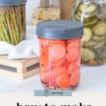 Three jars of homemade pickled vegetables—radishes, cucumbers, and asparagus—sit on a kitchen counter, illustrating how to make pickles with fresh ingredients.