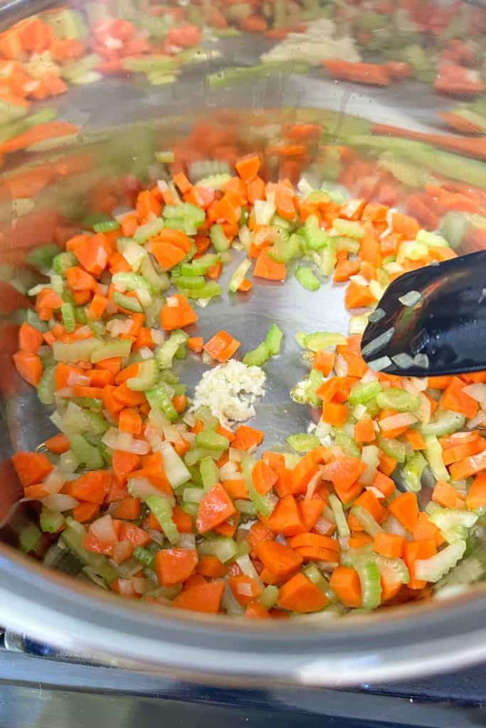 Carrots, onion, celery, and garlic sauteeing in soup pot.