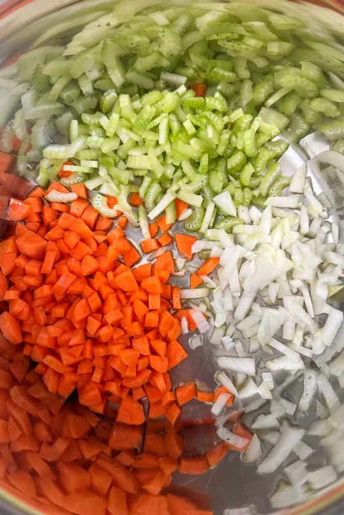 Carrots, onions, and celery in a soup pot.