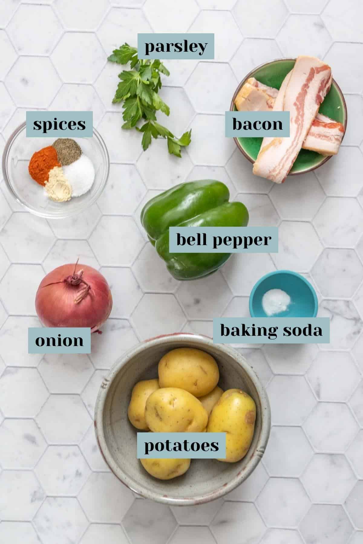 Ingredients for breakfast potatoes on a tile surface with labels.