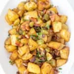 Roasted breakfast potatoes on a white serving plate.