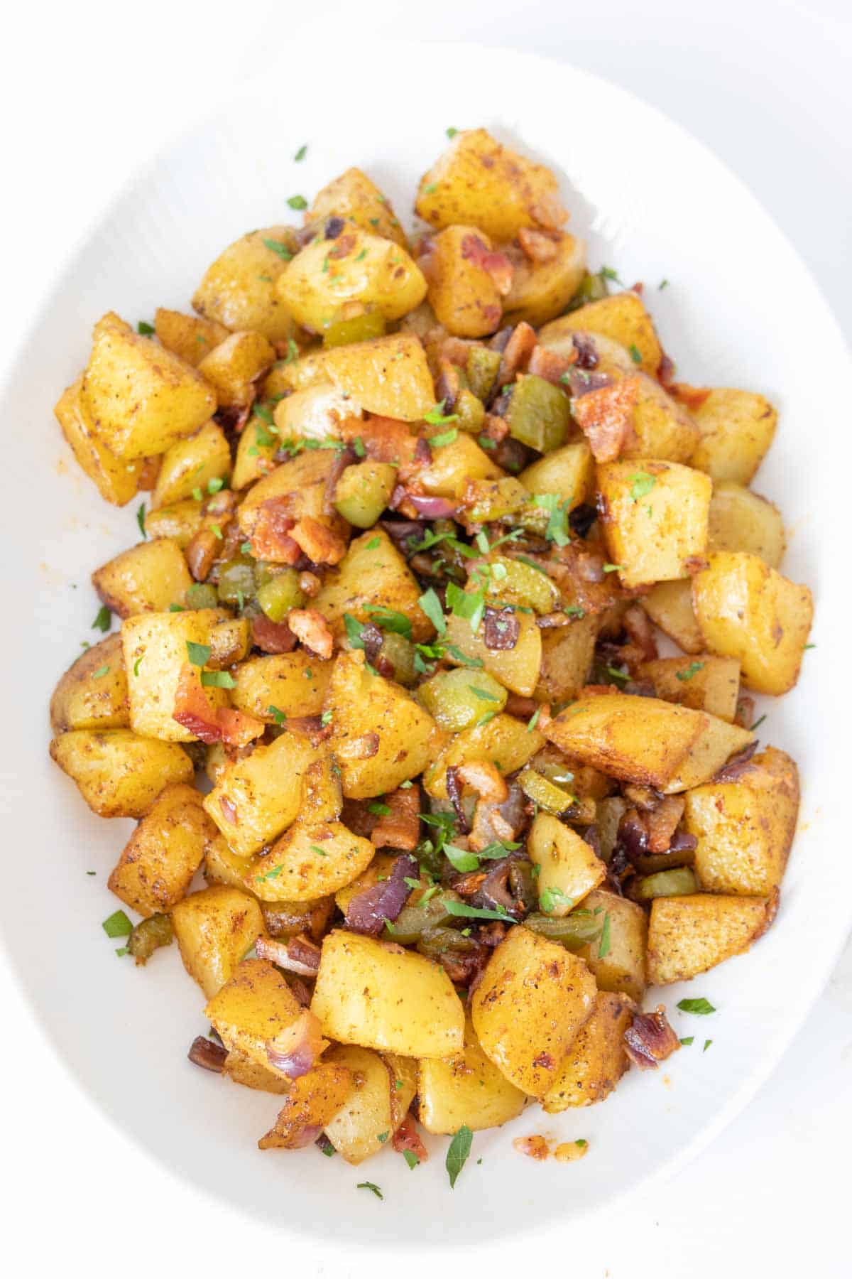 Roasted breakfast potatoes on a white serving plate.