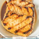 Four teriyaki pork chops in a bowl, glazed with glossy teriyaki sauce and accented by perfect grill marks. Text overlay reads "teriyaki pork chops.