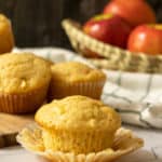 Unwrapped apple muffin sitting on the paper liner.