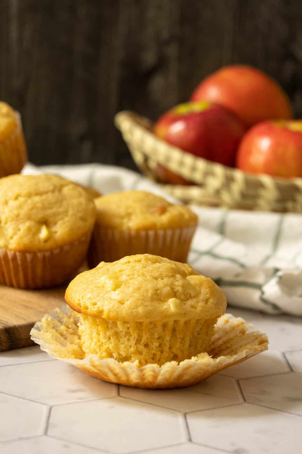 Unwrapped apple muffin sitting on the paper liner.