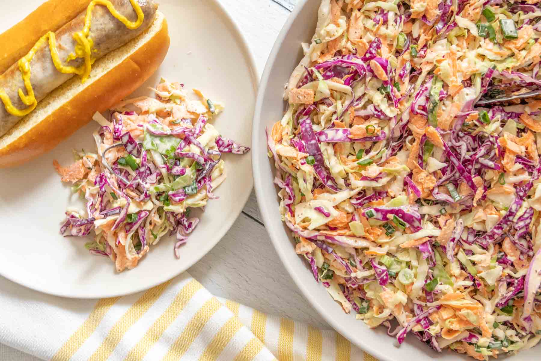 Overhead of coleslaw on a plate and in a large serving dish.