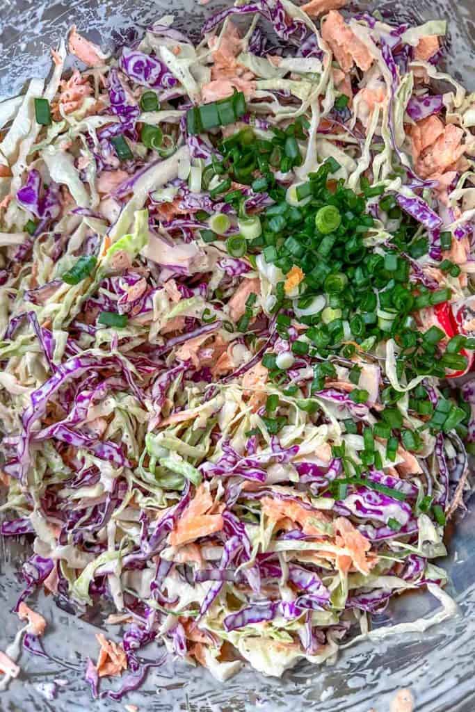 Mixing homemade coleslaw together in a large bowl.