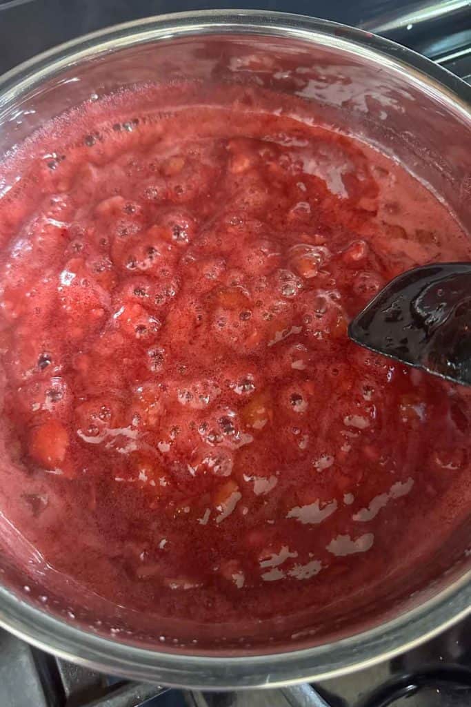 Strawberry rhubarb jam cooking on the stove.