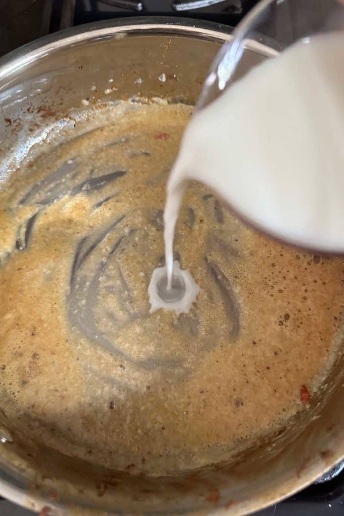 Pouring milk into a saucepan.