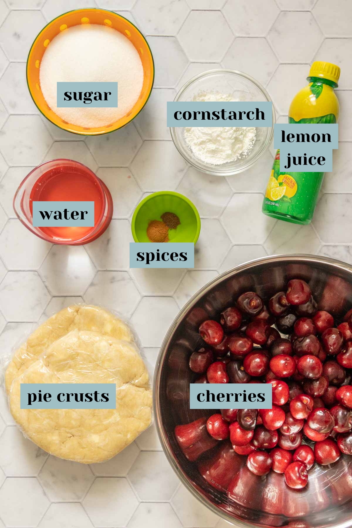 Ingredients for cherry pie on a tile surface with labels.