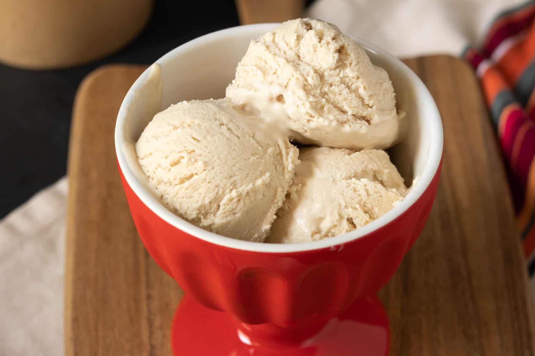 Bowl of no-churn ice cream set on a wooden board.