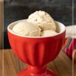A red bowl filled with three scoops of creamy no-churn ice cream sits on a wooden surface. Text at the top reads "No Churn Ice Cream.
