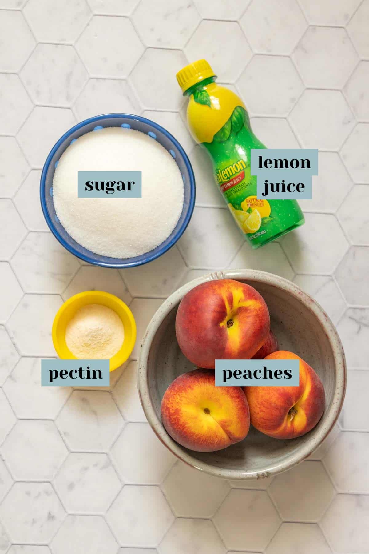 Ingredients for peach jam on a tile surface with labels.