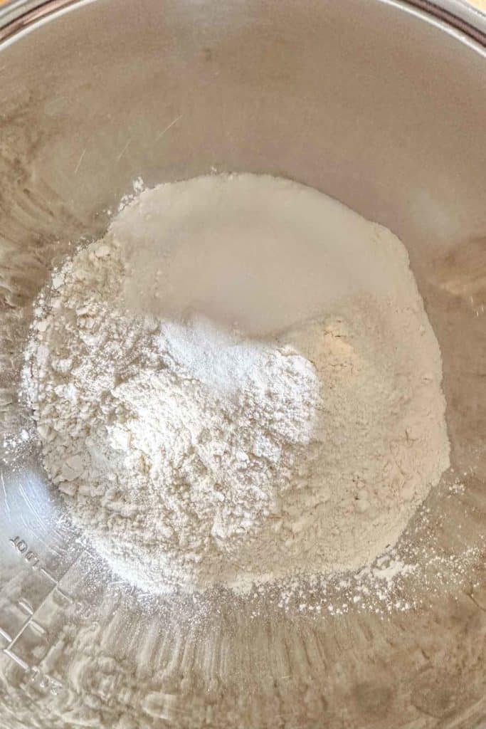 Flour, sugar, and salt in a mixing bowl to make pie dough.