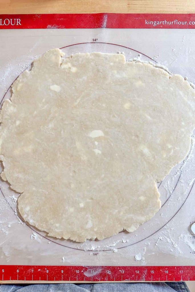 Rolled out pie crust on pastry mat.