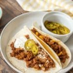 Plate with two ground bison tacos in flour tortillas.