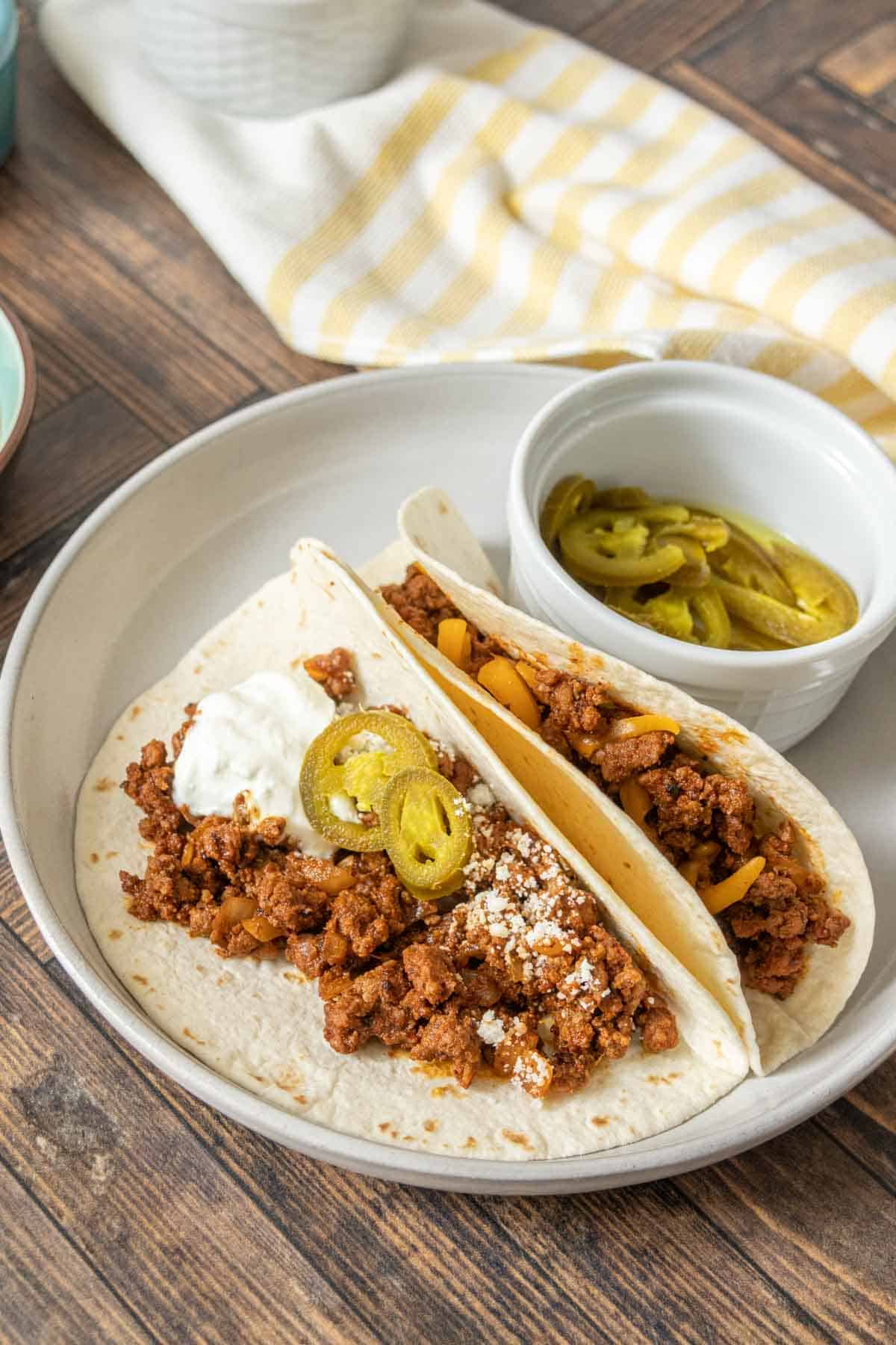 Plate with two ground bison tacos in flour tortillas.