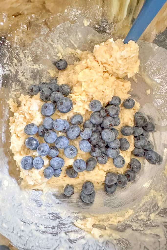 Blueberries added to scone dough in a mixing bowl.