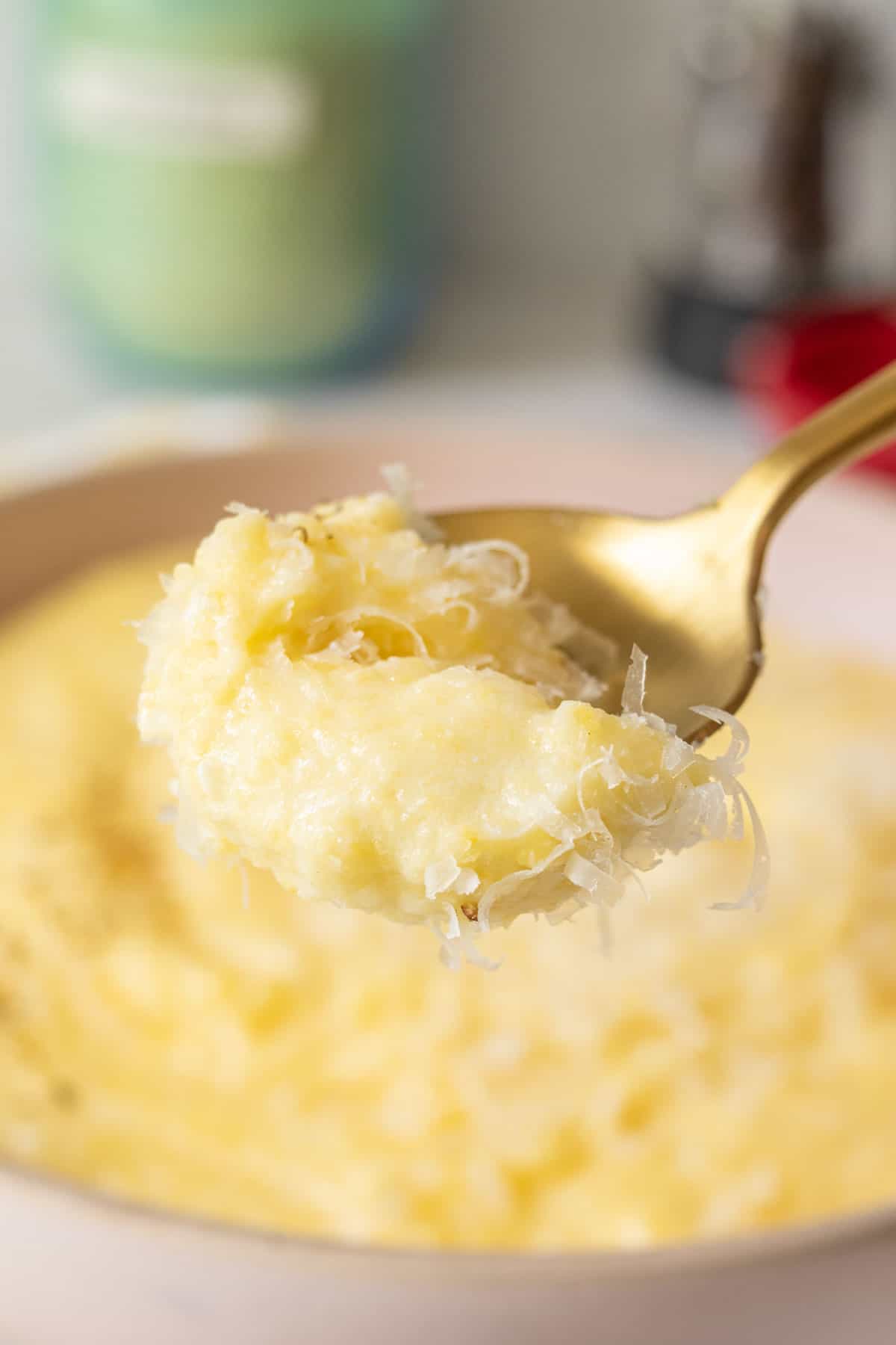 Spoonful of cheesy polenta held close up.