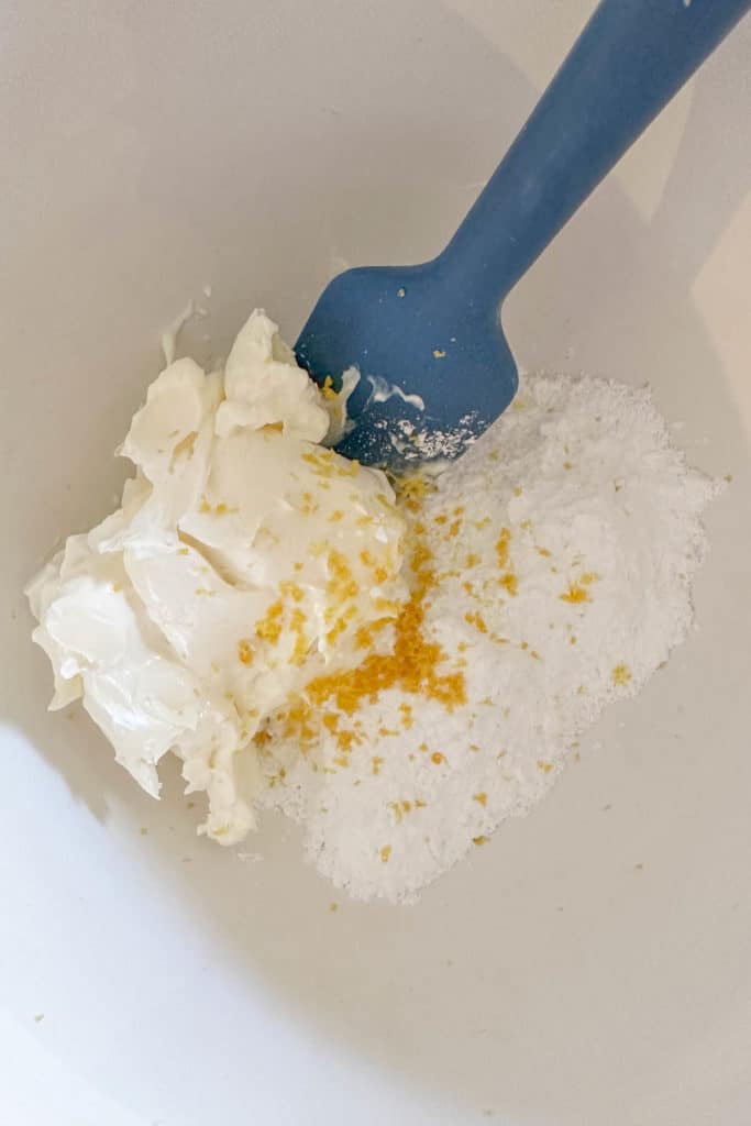 Mixing bowl with mascarpone, powdered sugar, and lemon zest.