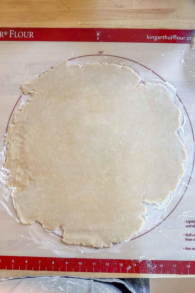 Rolled out pie dough for galette on a pastry mat.