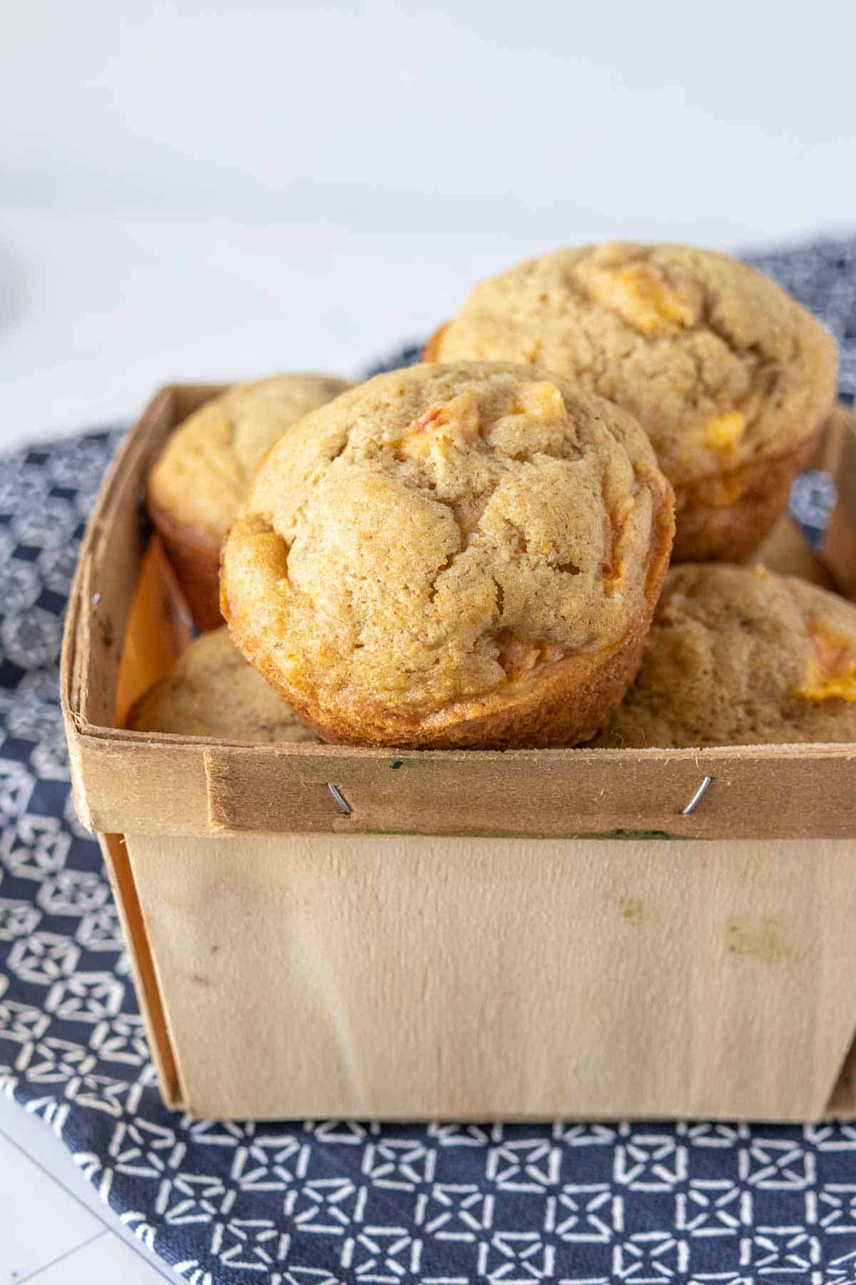 Peach muffins in a fruit basket.