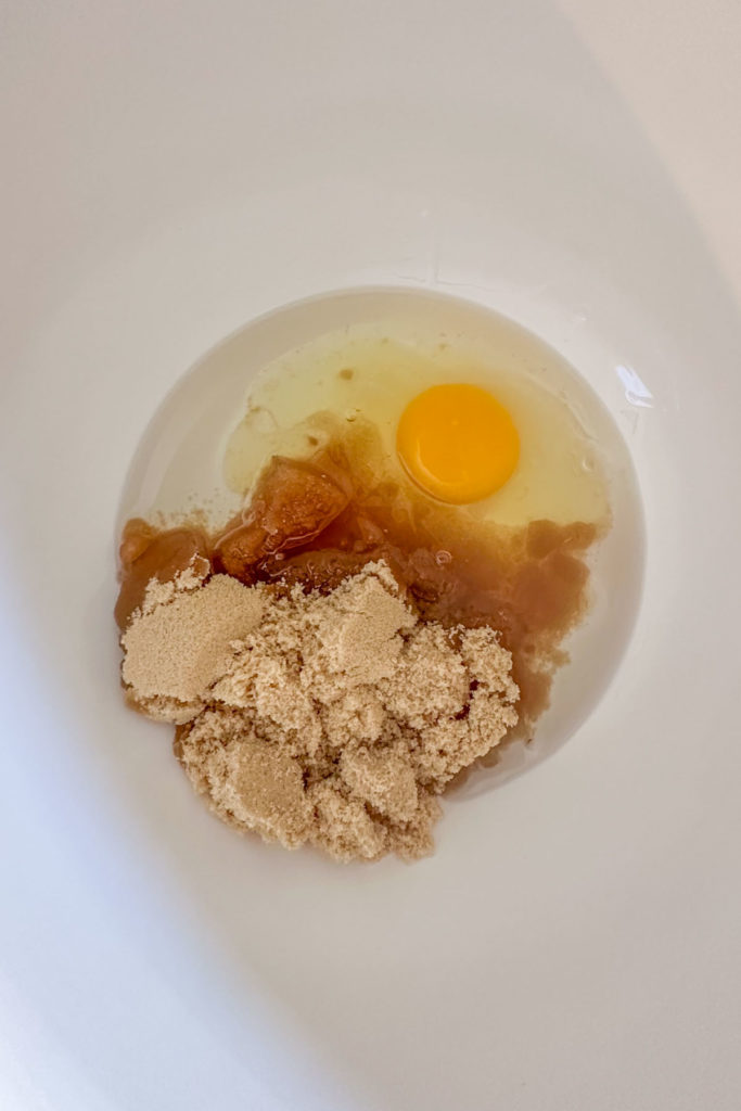 Brown sugar, egg, and vegetable oil in a mixing bowl.