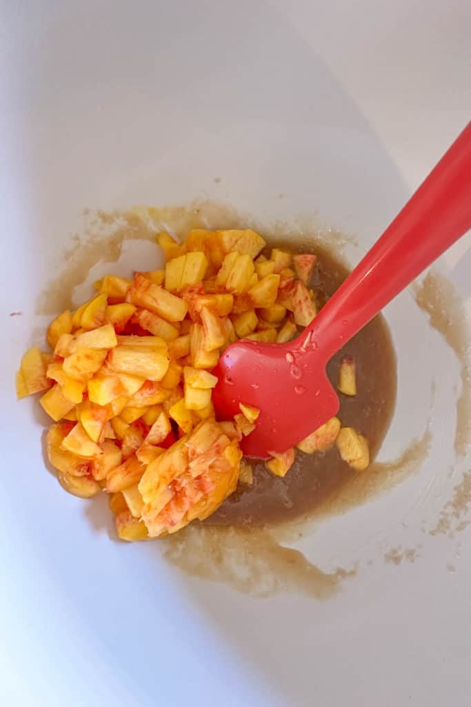 Stirring peaches into egg sugar mixture.