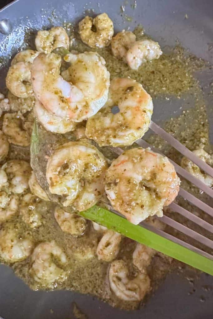 Cooked pesto shrimp in frying pan.