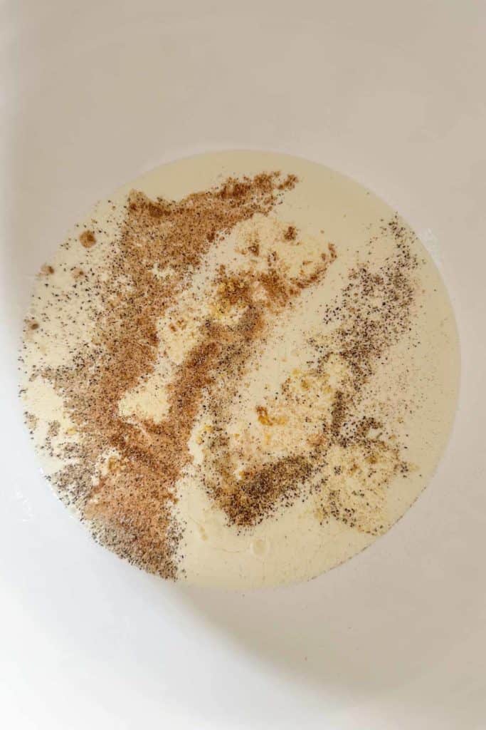 Eggs, cream, and spices in a mixing bowl before mixing together.