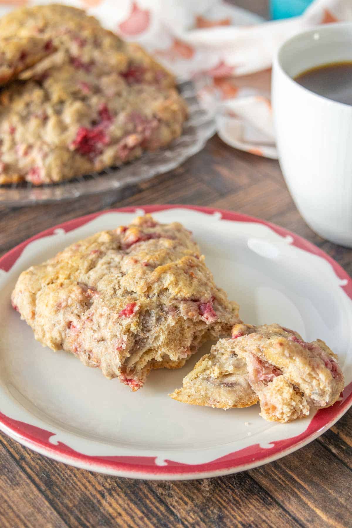 Raspberry scone broken apart on a small plate.