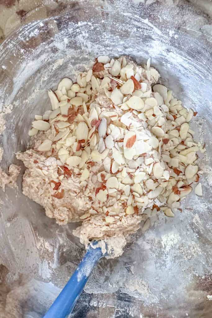 Almonds being added to scone dough in mixing bowl.