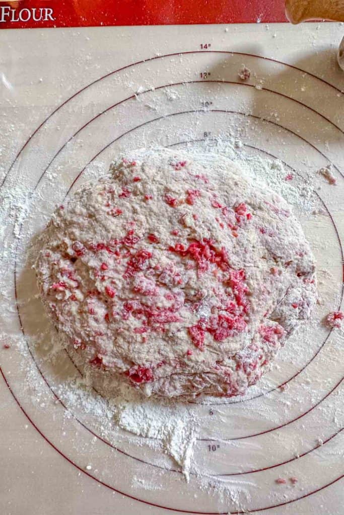 Scone dough formed into a circle on a pastry mat.