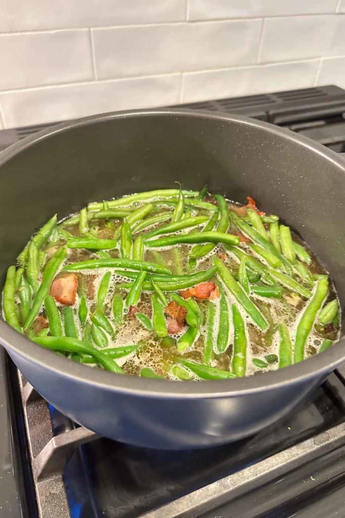 Simmering southern green beans in a pot on the stove.