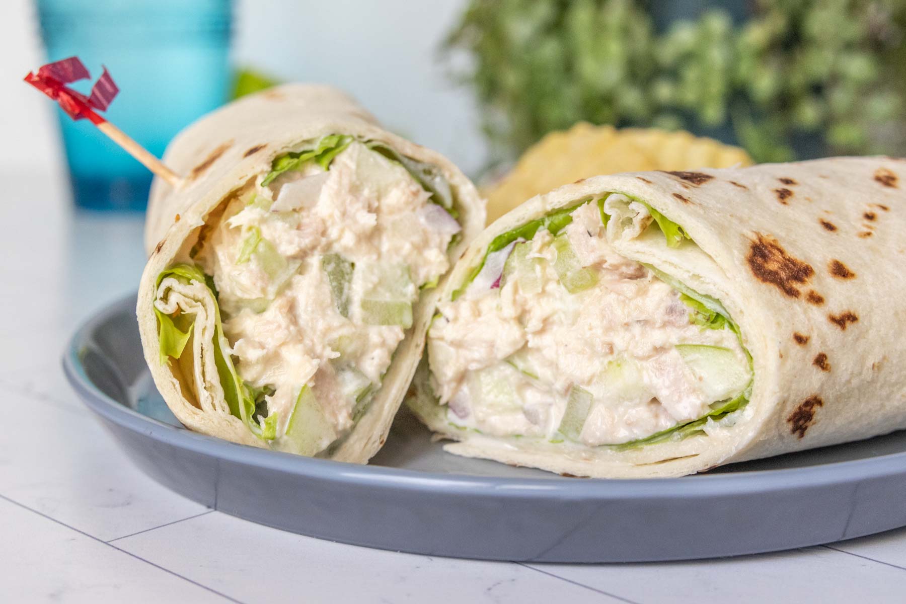 Cut tuna wrap on a gray plate, angled to show filling.