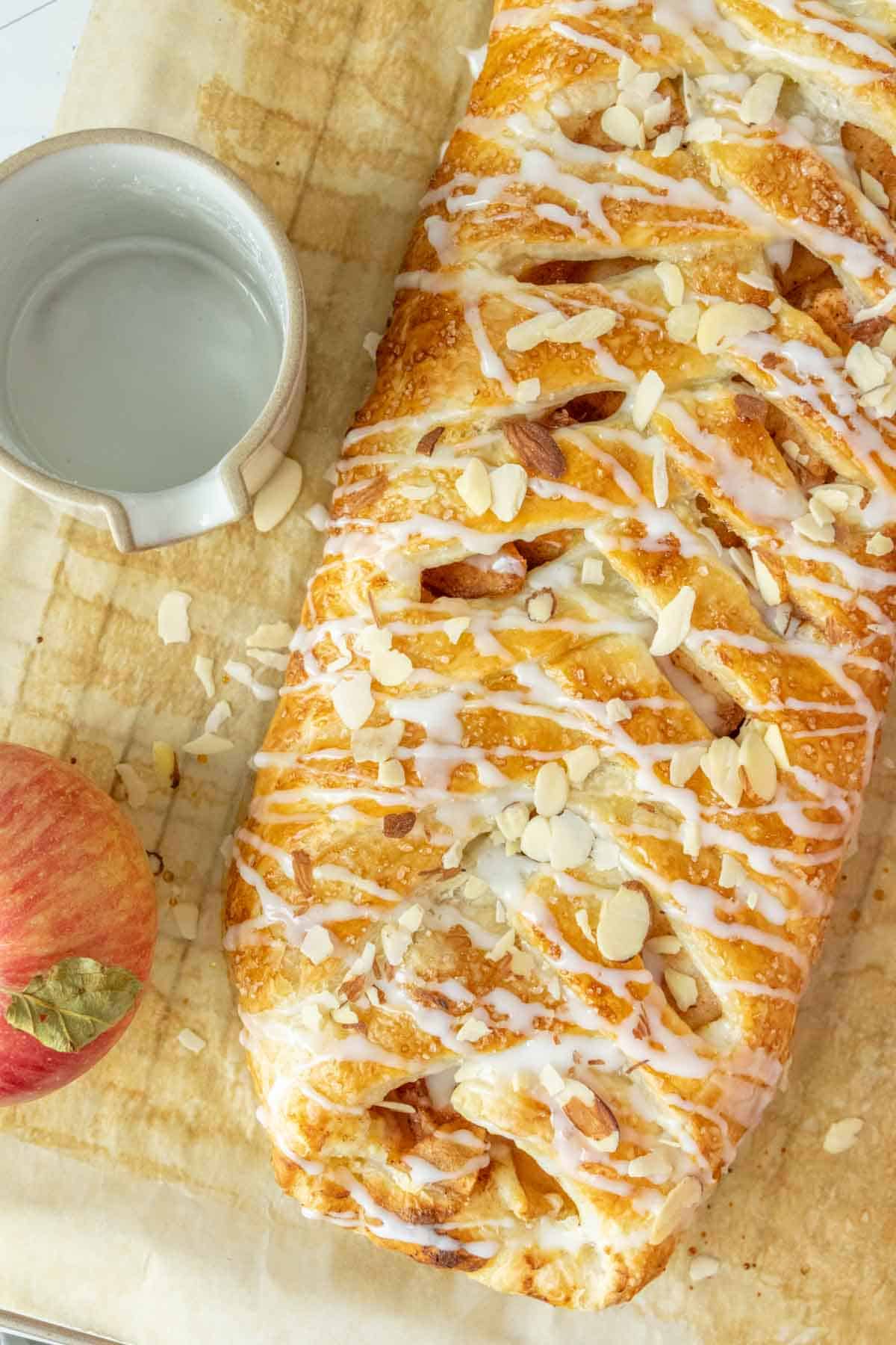 A braided apple pastry on a baking sheet.