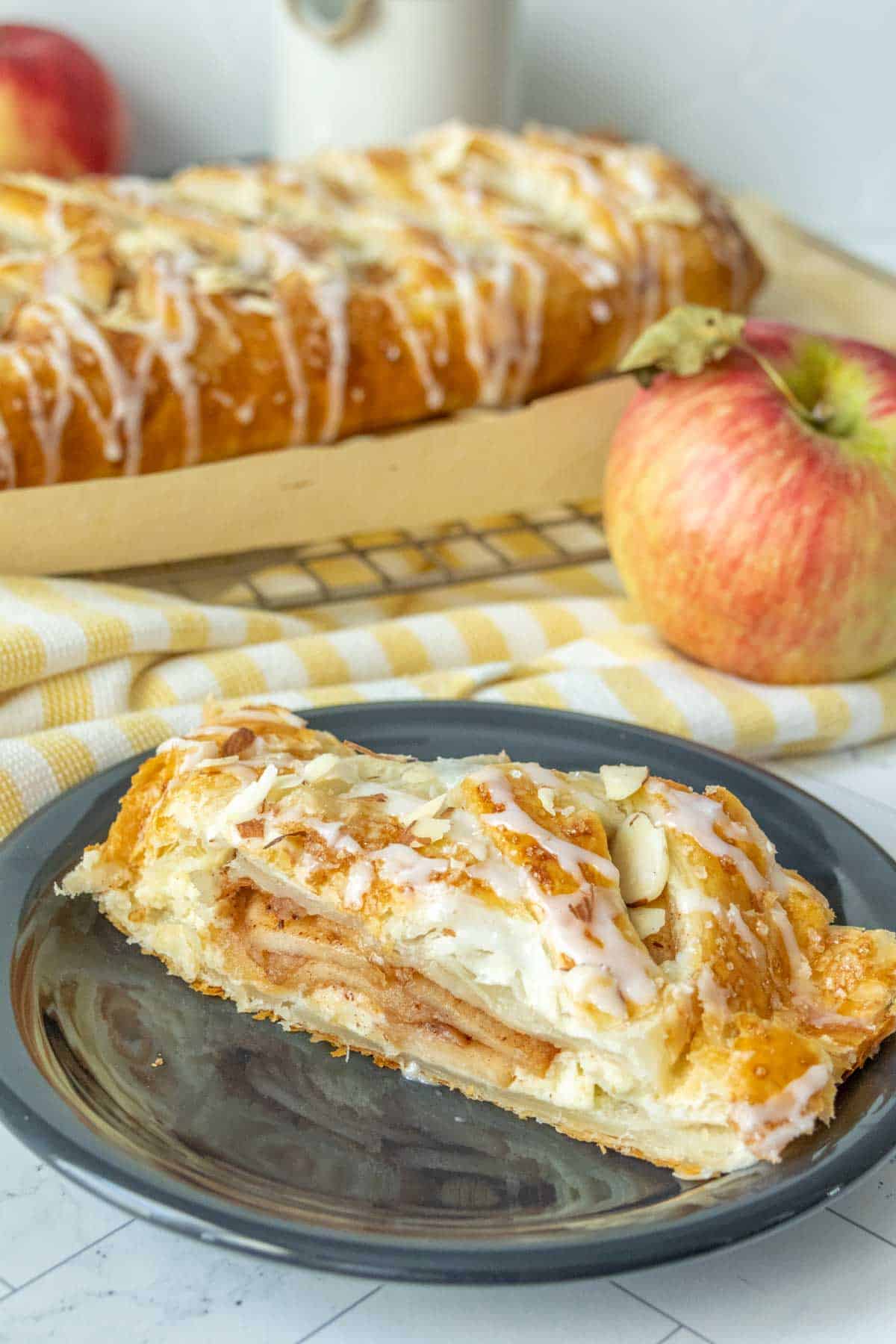 A slice of apple danish on a plate.