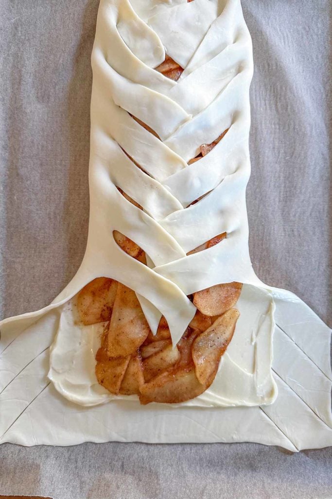 Apple danish pastry being folded over.