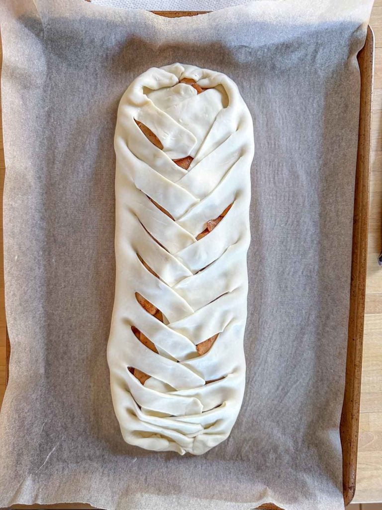 An unbaked apple danish on a baking sheet.