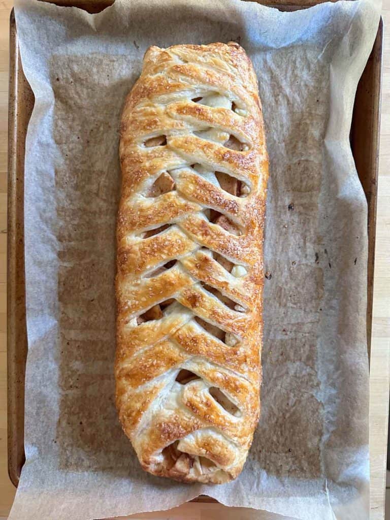 An apple pastry on a baking sheet.