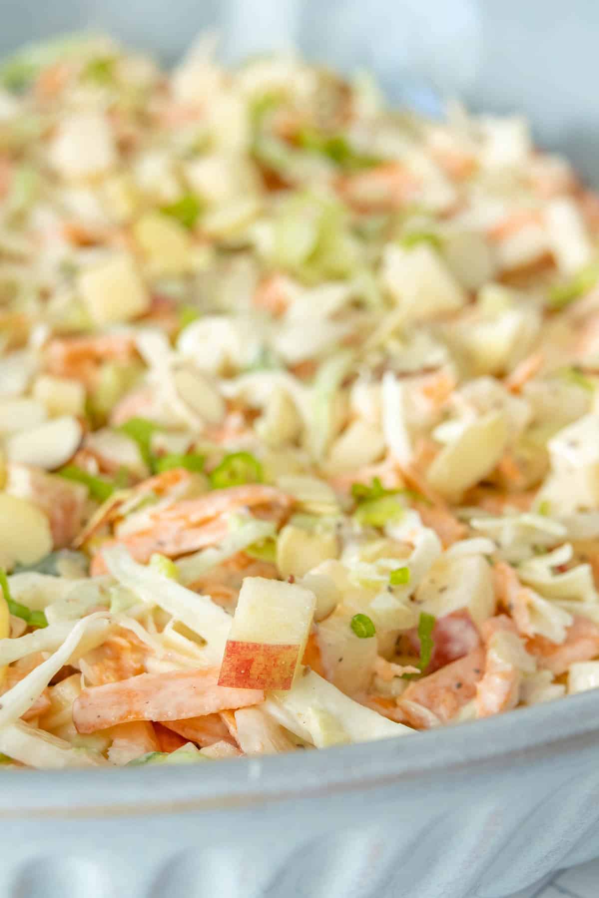 A dish of coleslaw with apples.