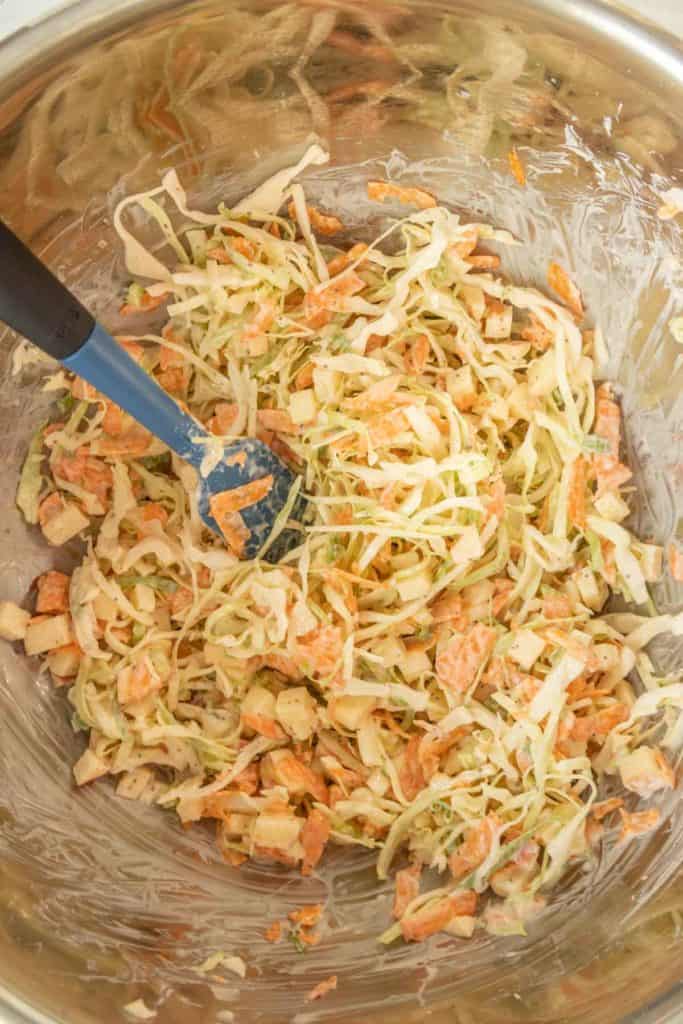 Coleslaw in a bowl with a spoon.