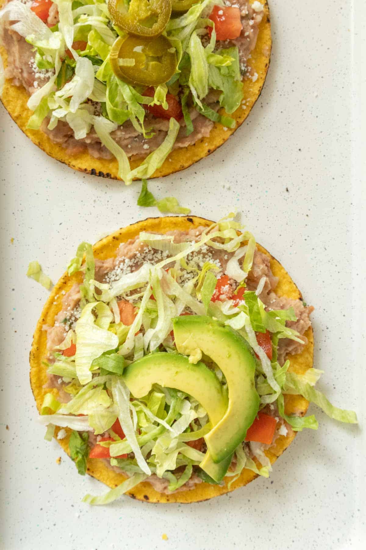Two tostadas on a white plate.