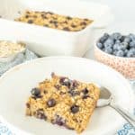 A plate of baked oatmeal with blueberries and oats.