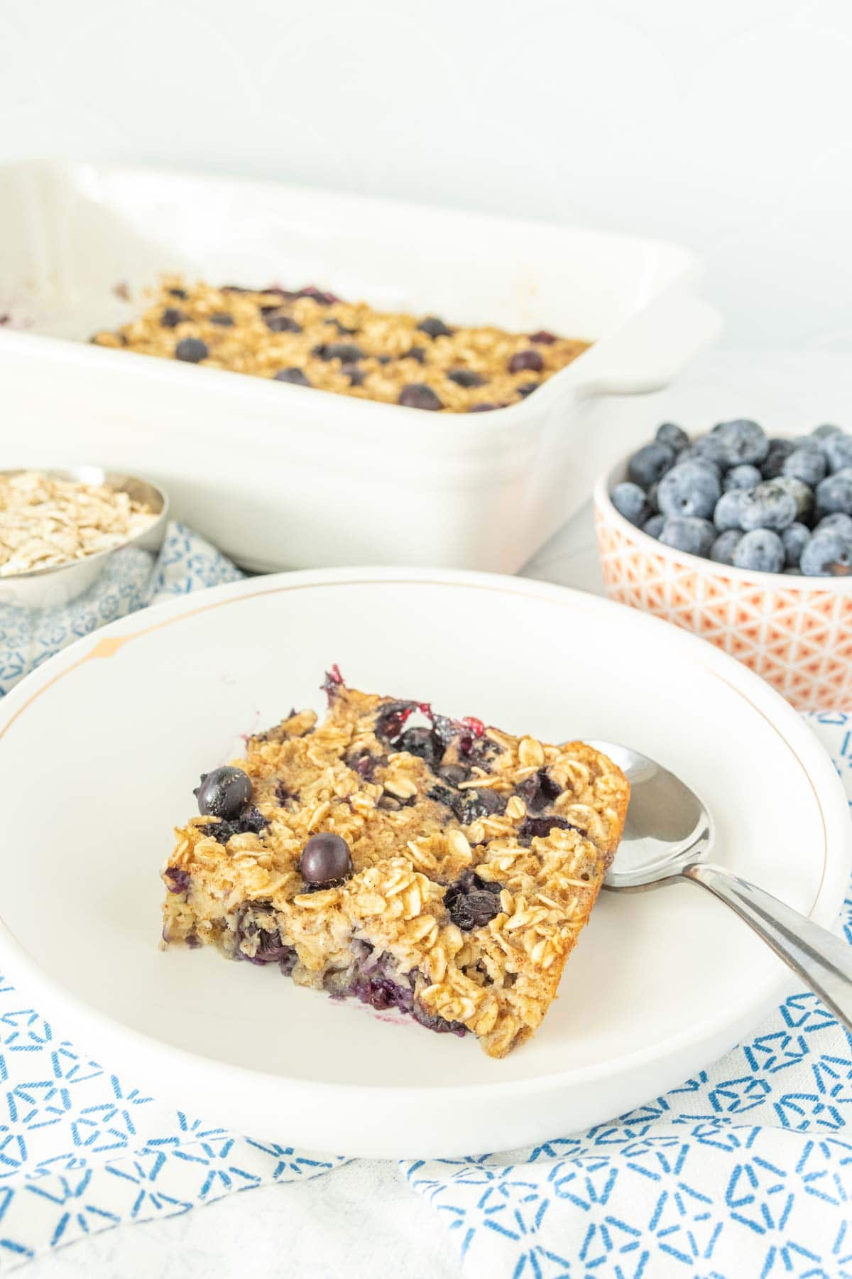 A plate of baked oatmeal with blueberries and oats.