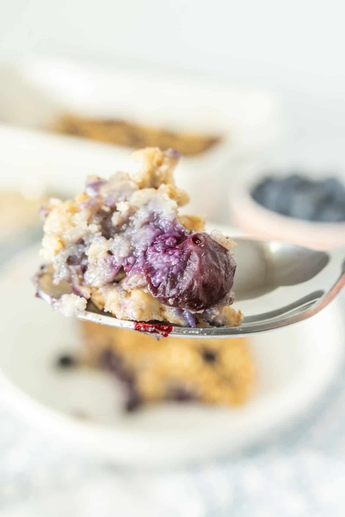 A spoonful of baked oatmeal with blueberries on it.