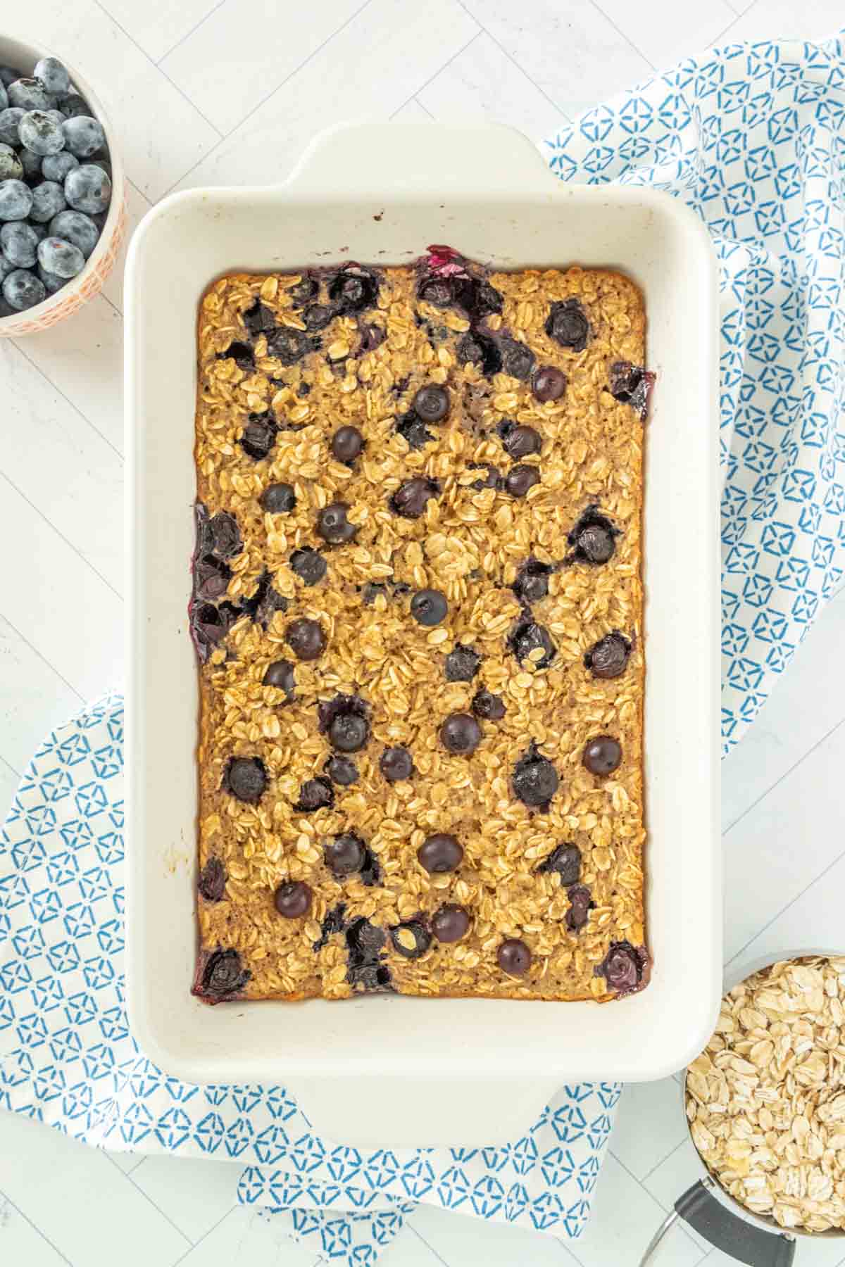 Blueberry oatmeal in a baking dish with blueberries.