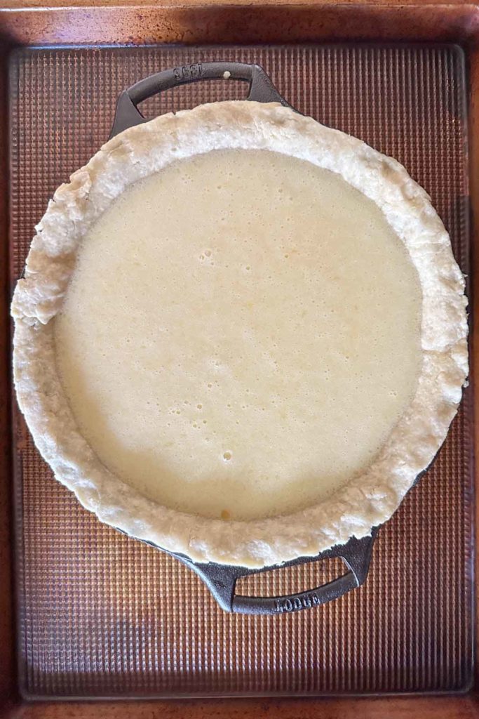 Unbaked buttermilk pie in a cast iron pan.