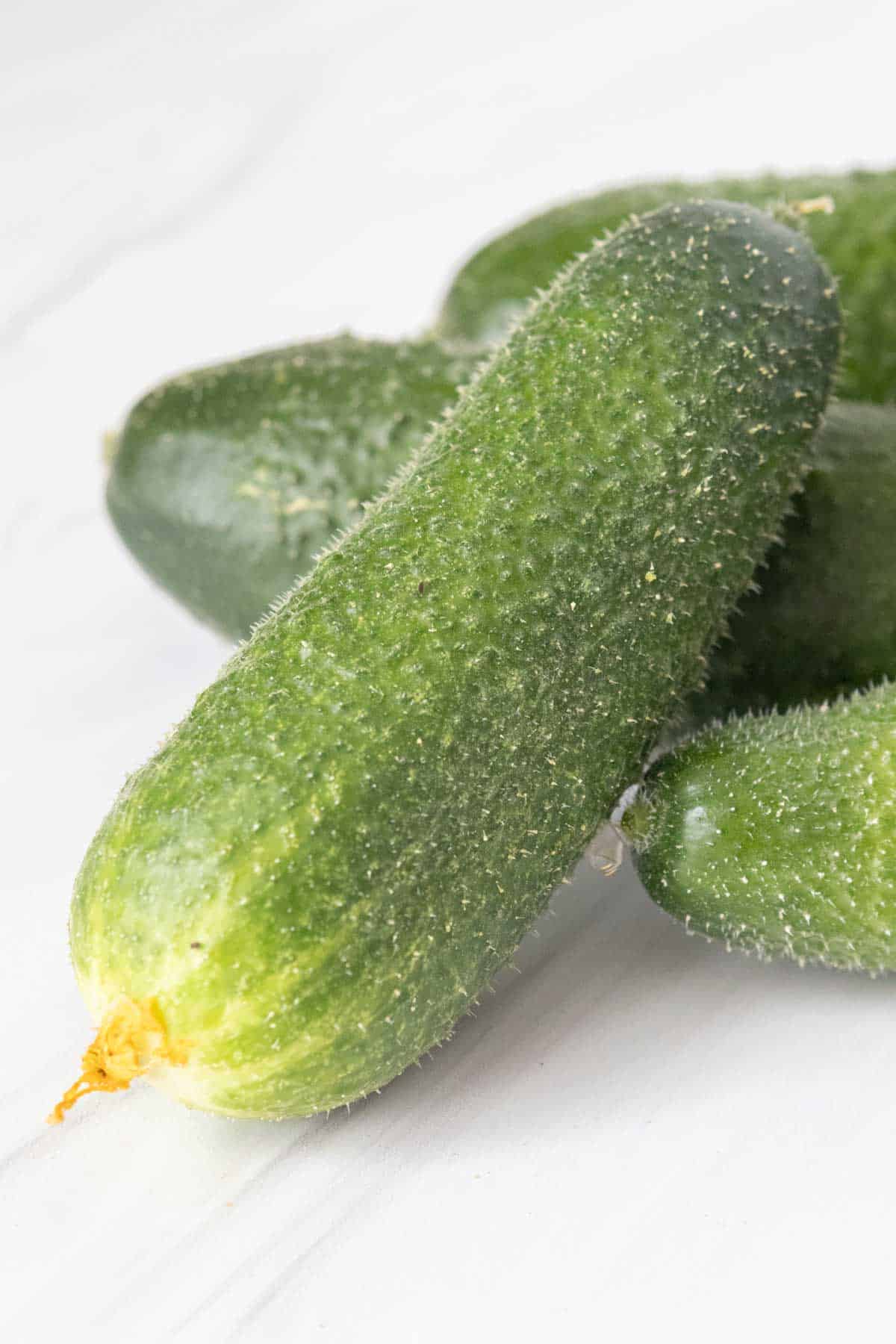 A group of cucumbers on a white surface.